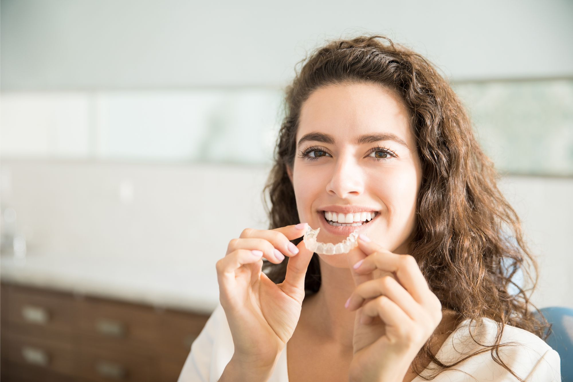 Orthodontist placing Invisalign tray on adult patient from Great Neck, NY.